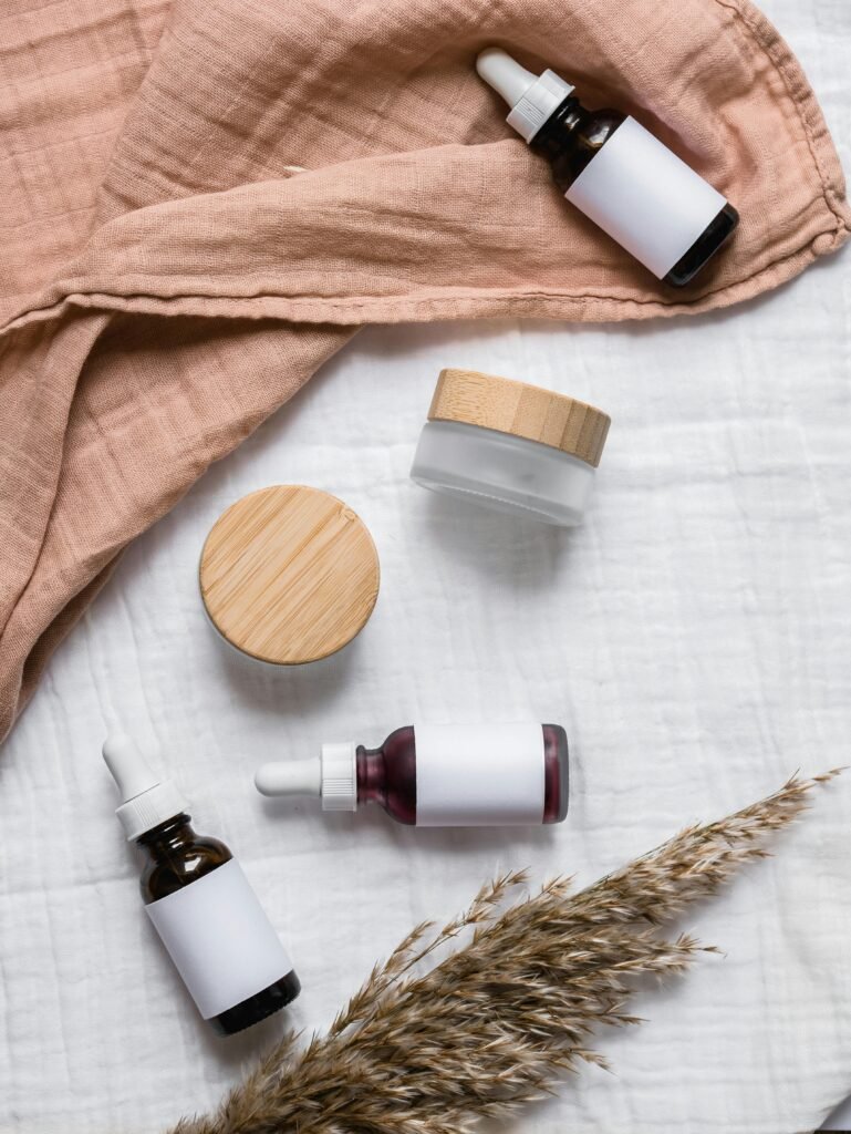 Stylish flat lay of serum bottles and jars on soft fabric with a natural, earthy aesthetic.
